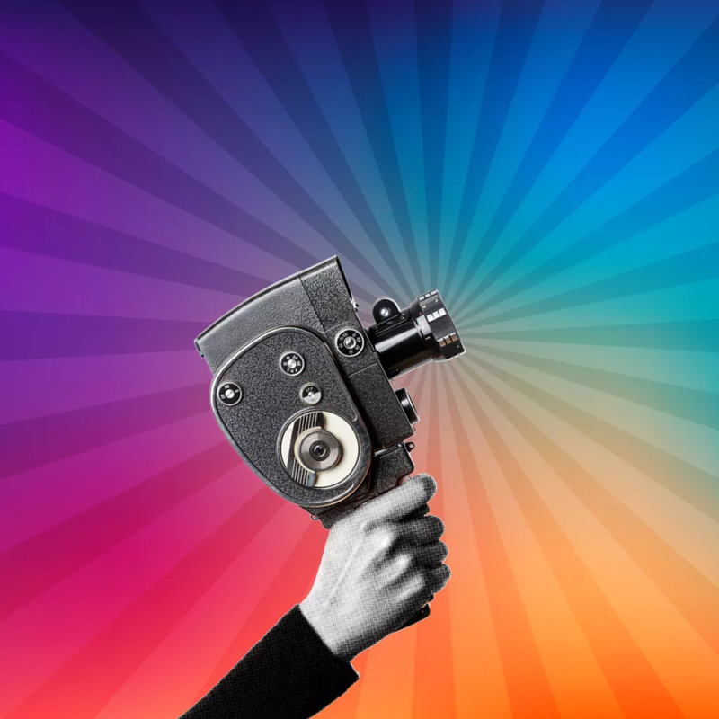 an old film camera held up against a rainbow background